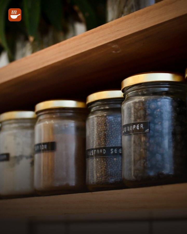 Glass storage jars lined up on a kitchen shelf
