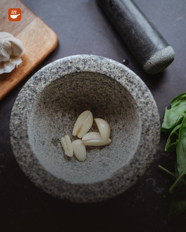 Granite mortar and pestle with garlic and fresh basil