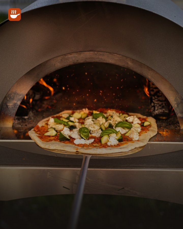 Pizza baking inside a wood-fired pizza oven