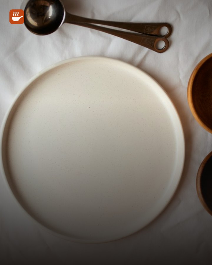 White ceramic plate with wooden bowls and a spoon